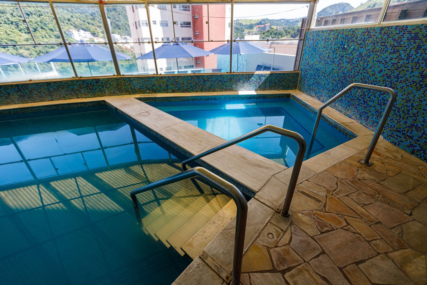 Uma grande piscina coberta com escadas que levam até ela.