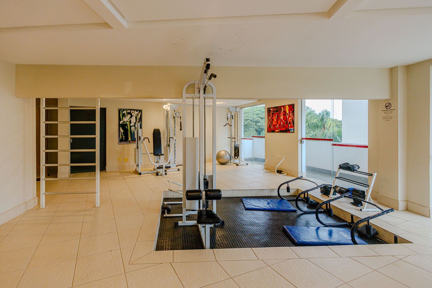 Uma sala grande com muitos equipamentos de exercícios.