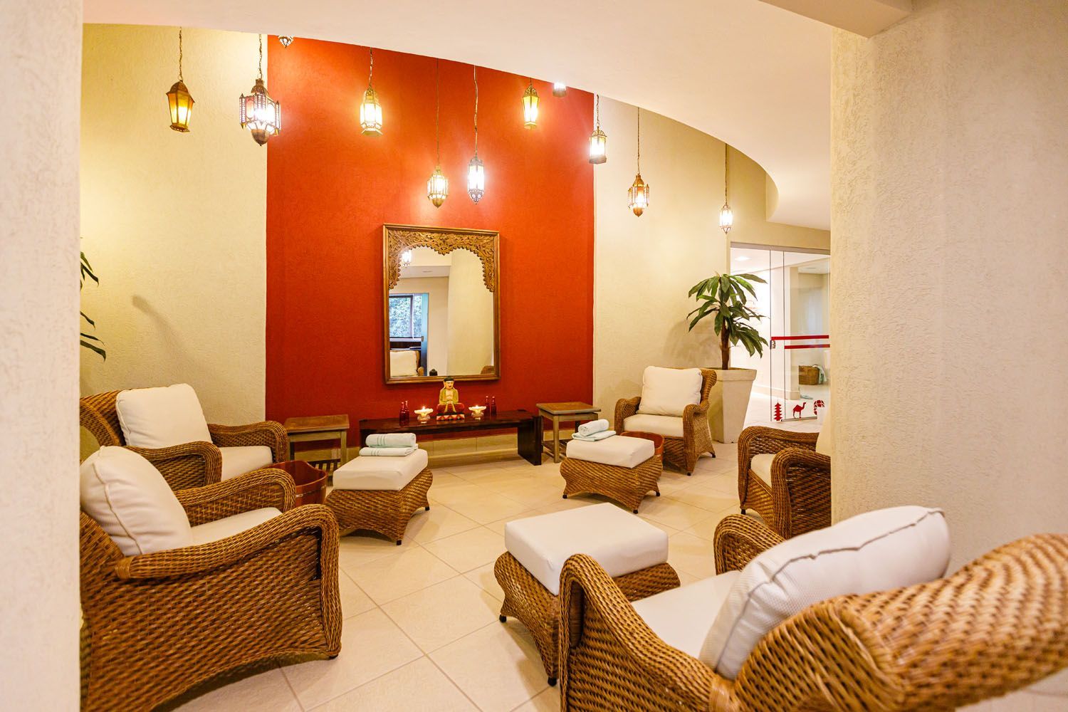 Uma pia de banheiro com uma vela e óleos essenciais em um balcão.