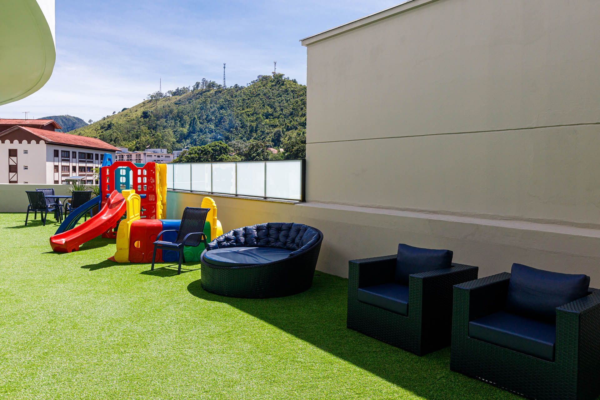 Há um playground com escorregador e cadeiras no quintal.