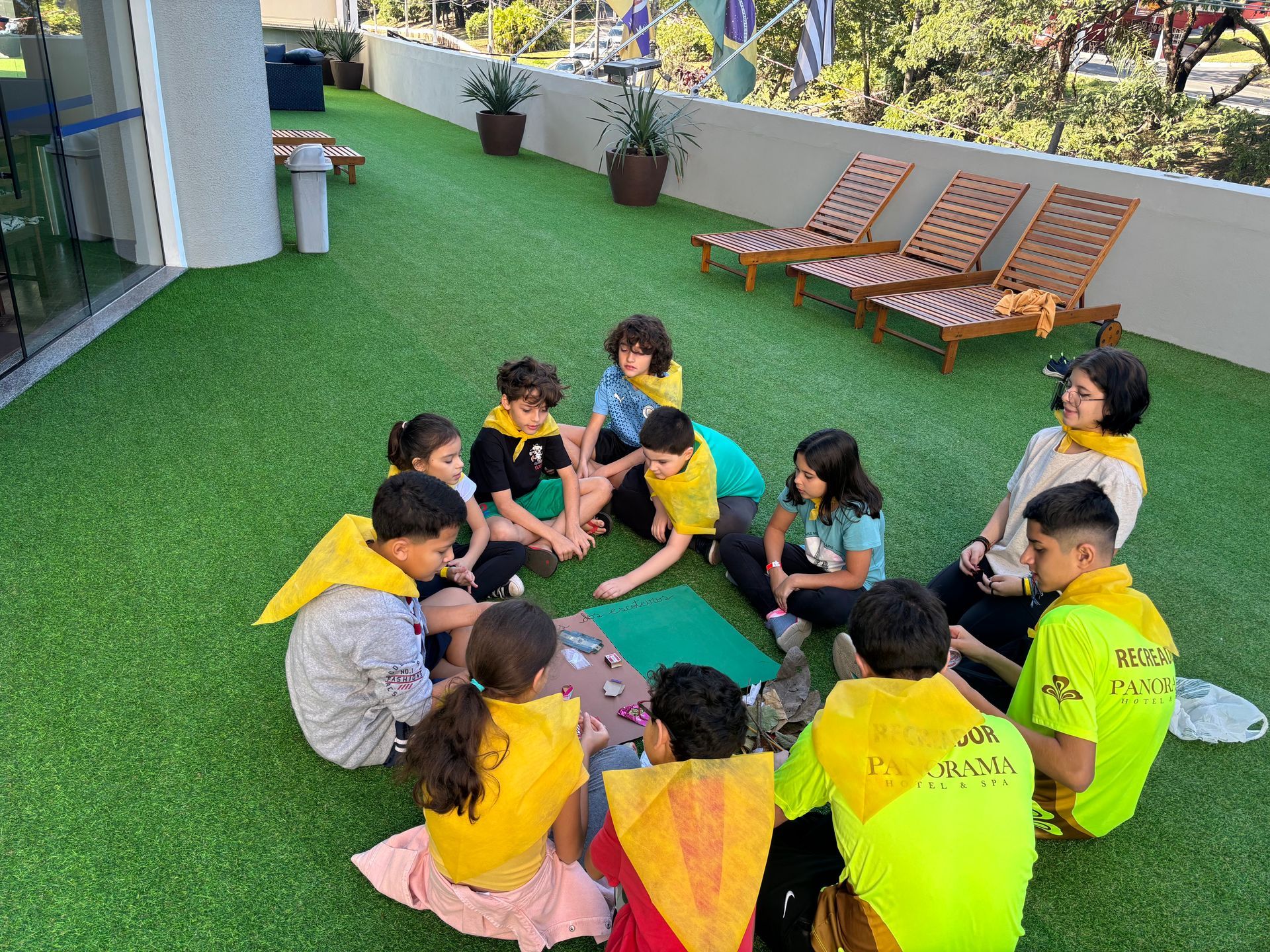 Uma família está sentada no sofá e fazendo sinal de positivo.