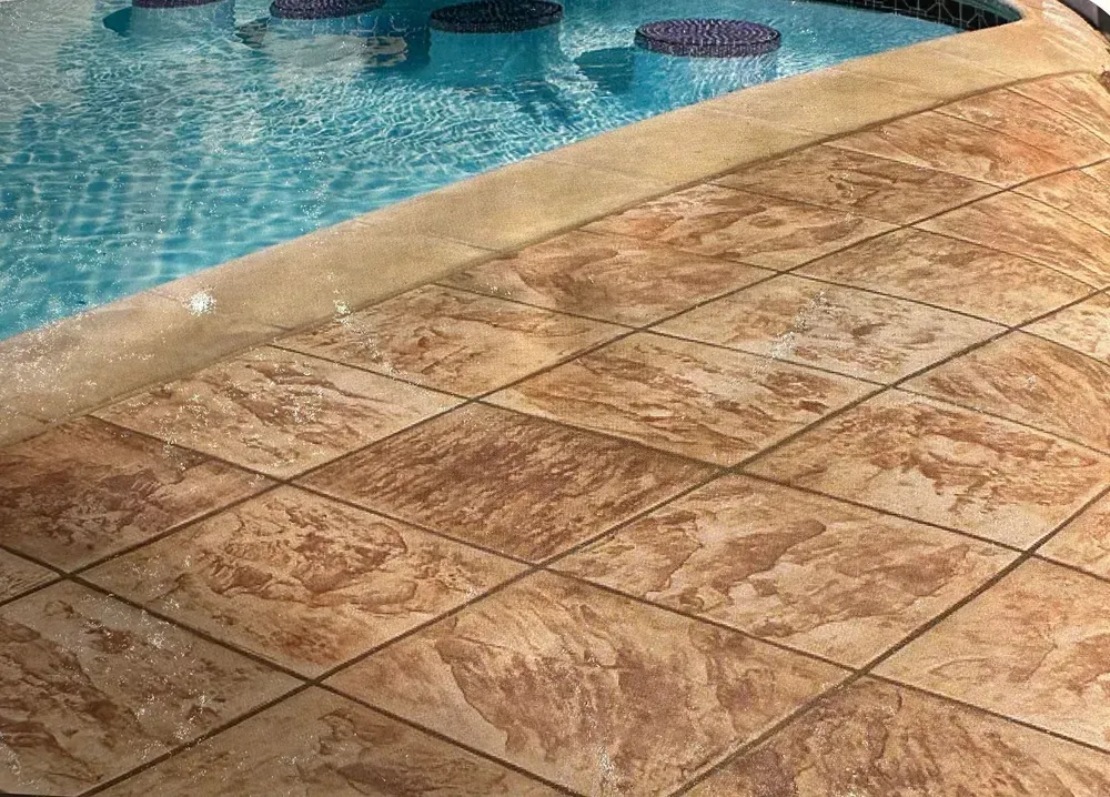 Blue swimming pool beside wet tan stone patio tiles.