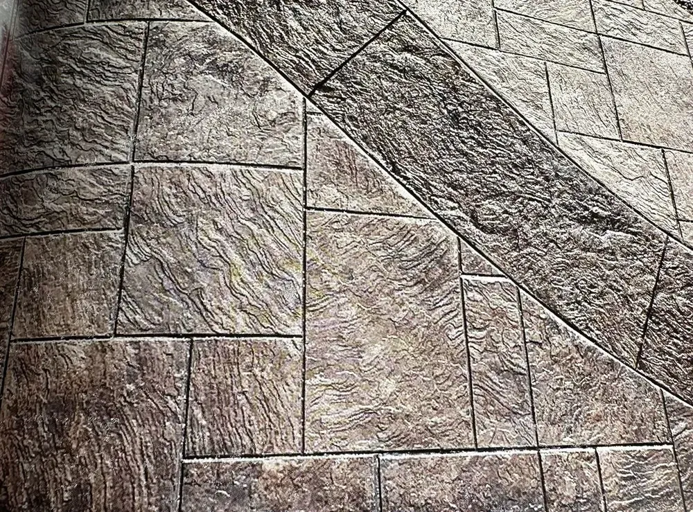 Textured stone pavement with rectangular tiles and a diagonal dark band