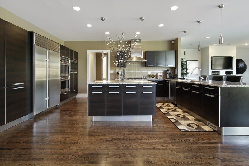 wood floor and white counter top kitchen with island