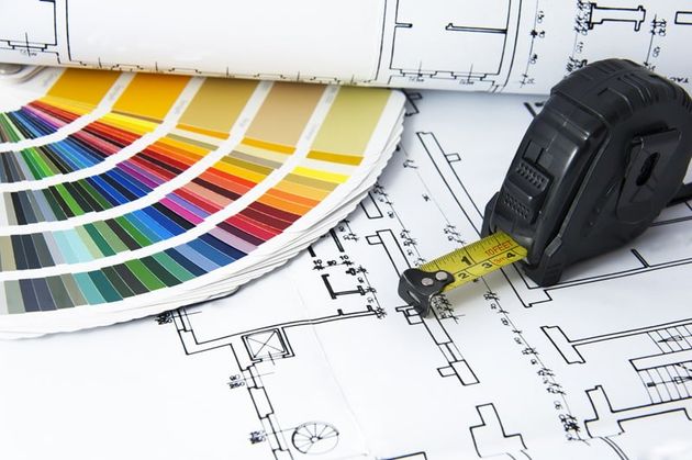 tape measure on building plans with paint colors near by