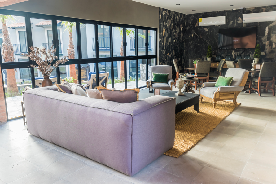 Una sala de estar con un sofá, sillas y una mesa.