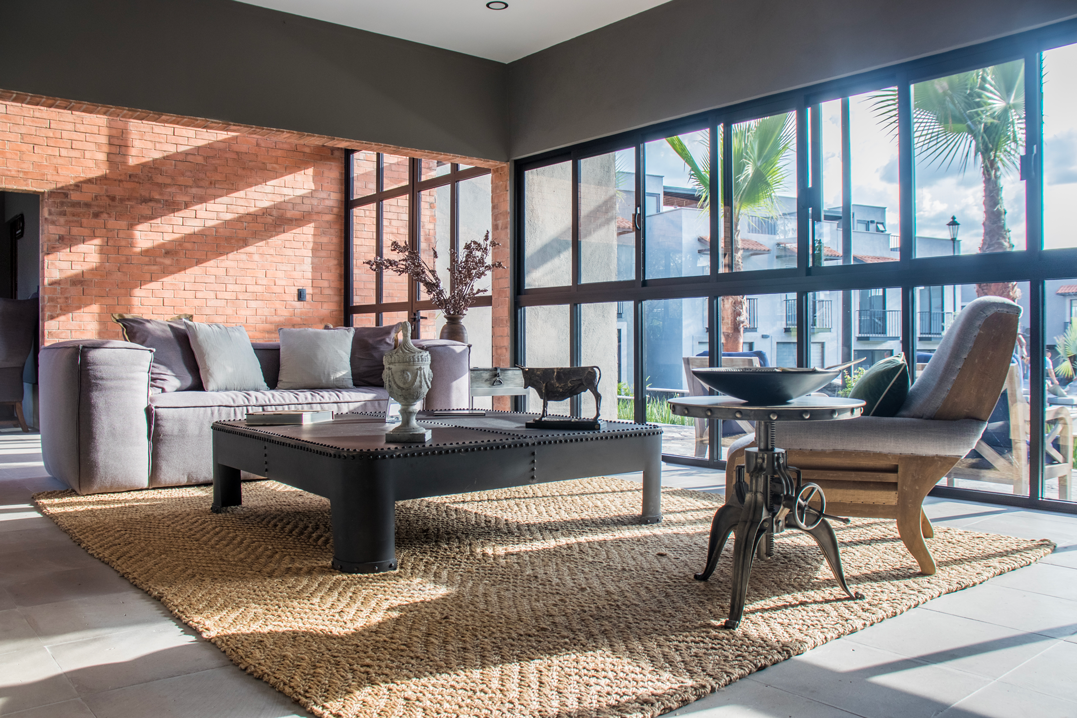 Es una sala con muchas ventanas y muebles.