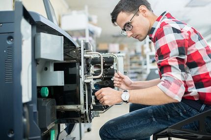 man repairing printer