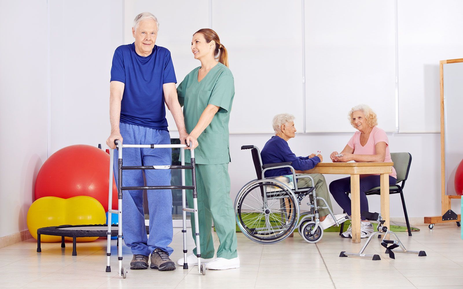 Un'infermiera aiuta un anziano a camminare con un deambulatore.