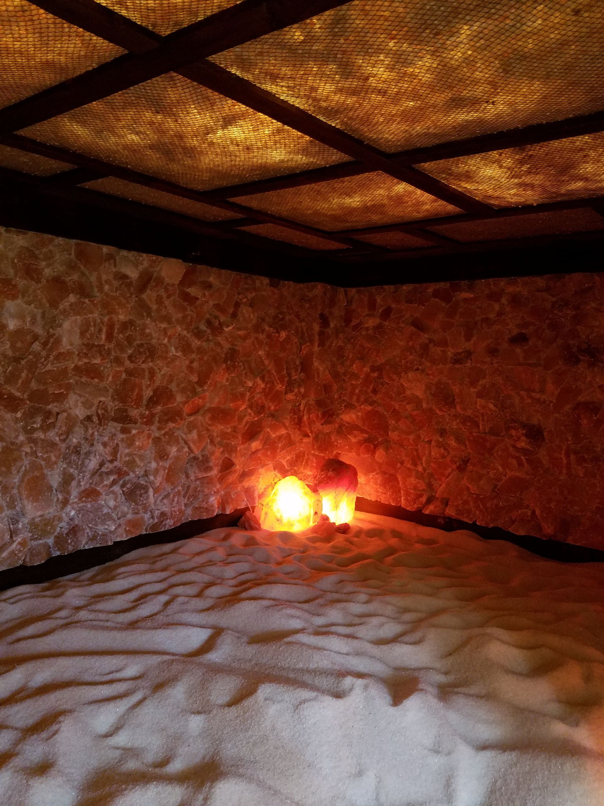 Salt cave with a lot of sand and two lights on the floor.