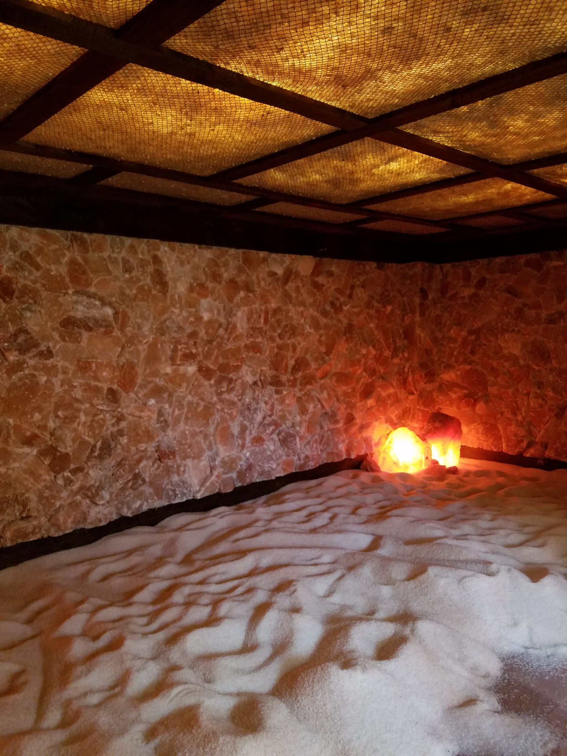 A room with a lot of sand and two lamps on the floor