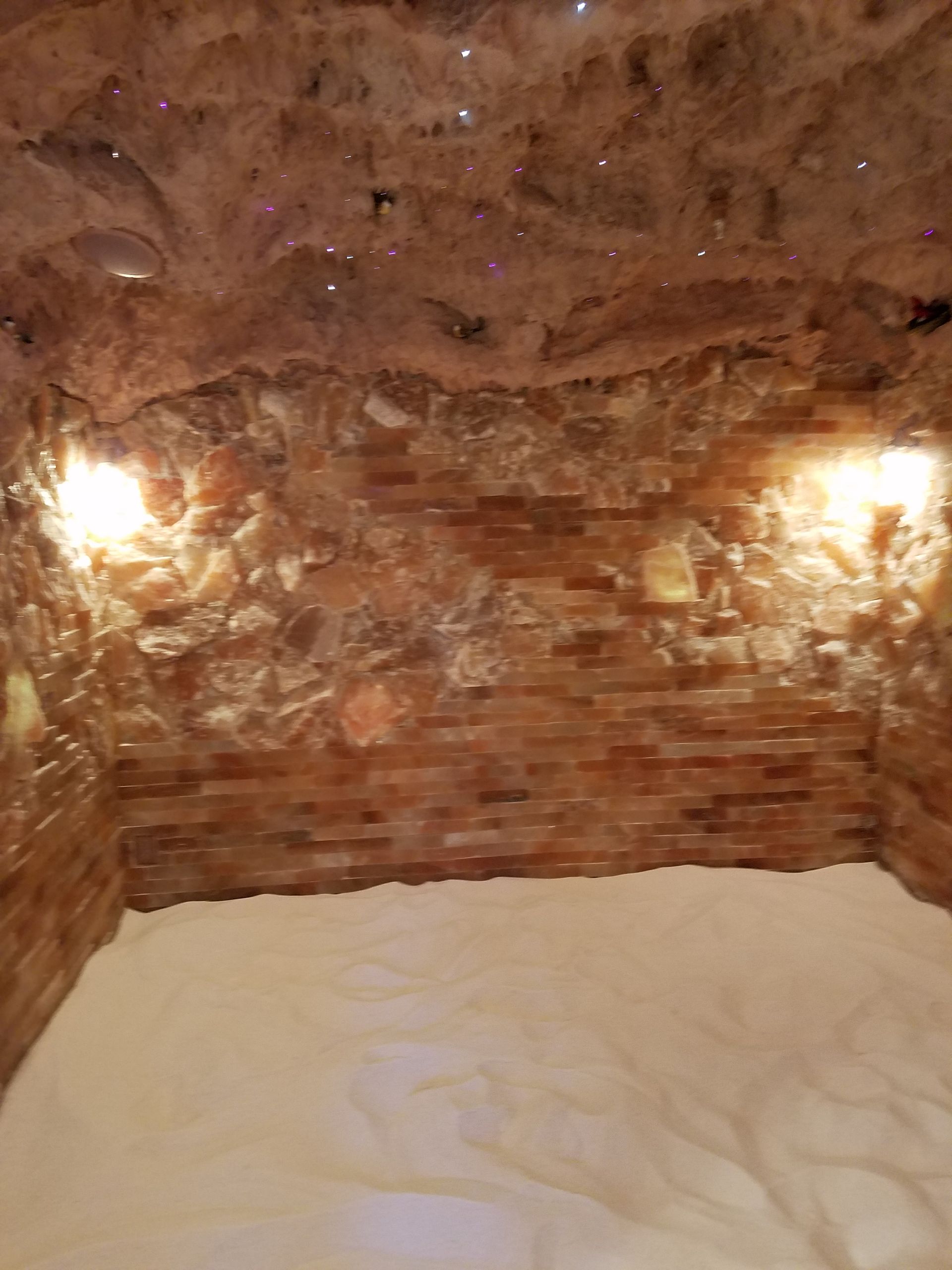 A room with a brick wall and a bed in it.