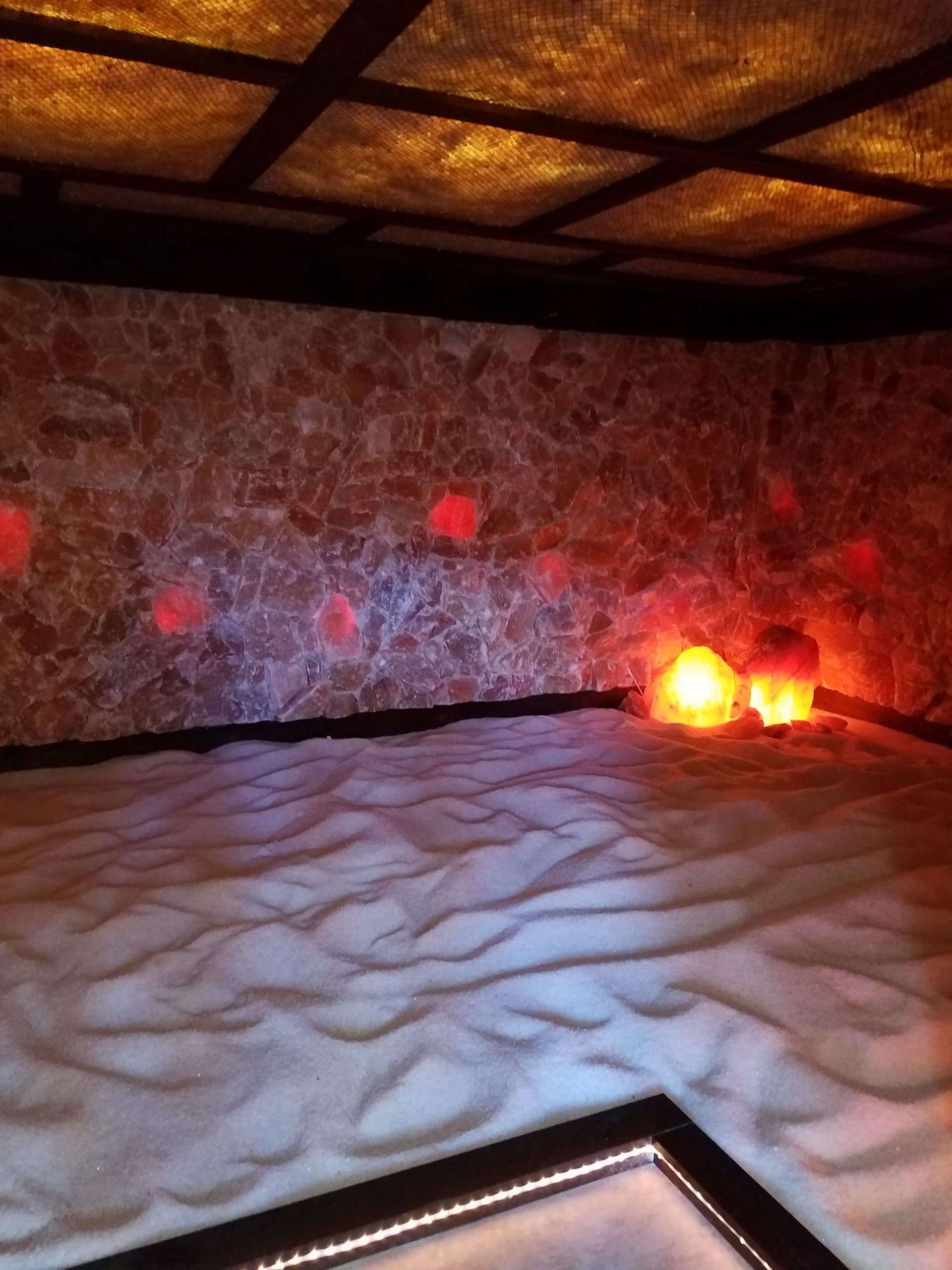 A room with a lot of sand and lights on the floor