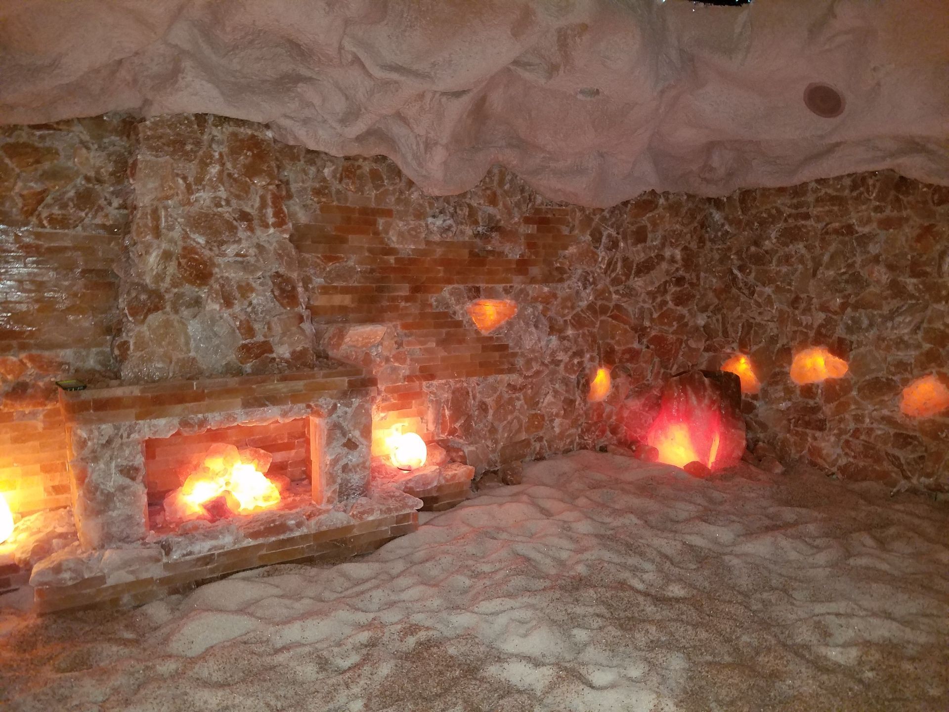 A room filled with rocks and candles and a fireplace.