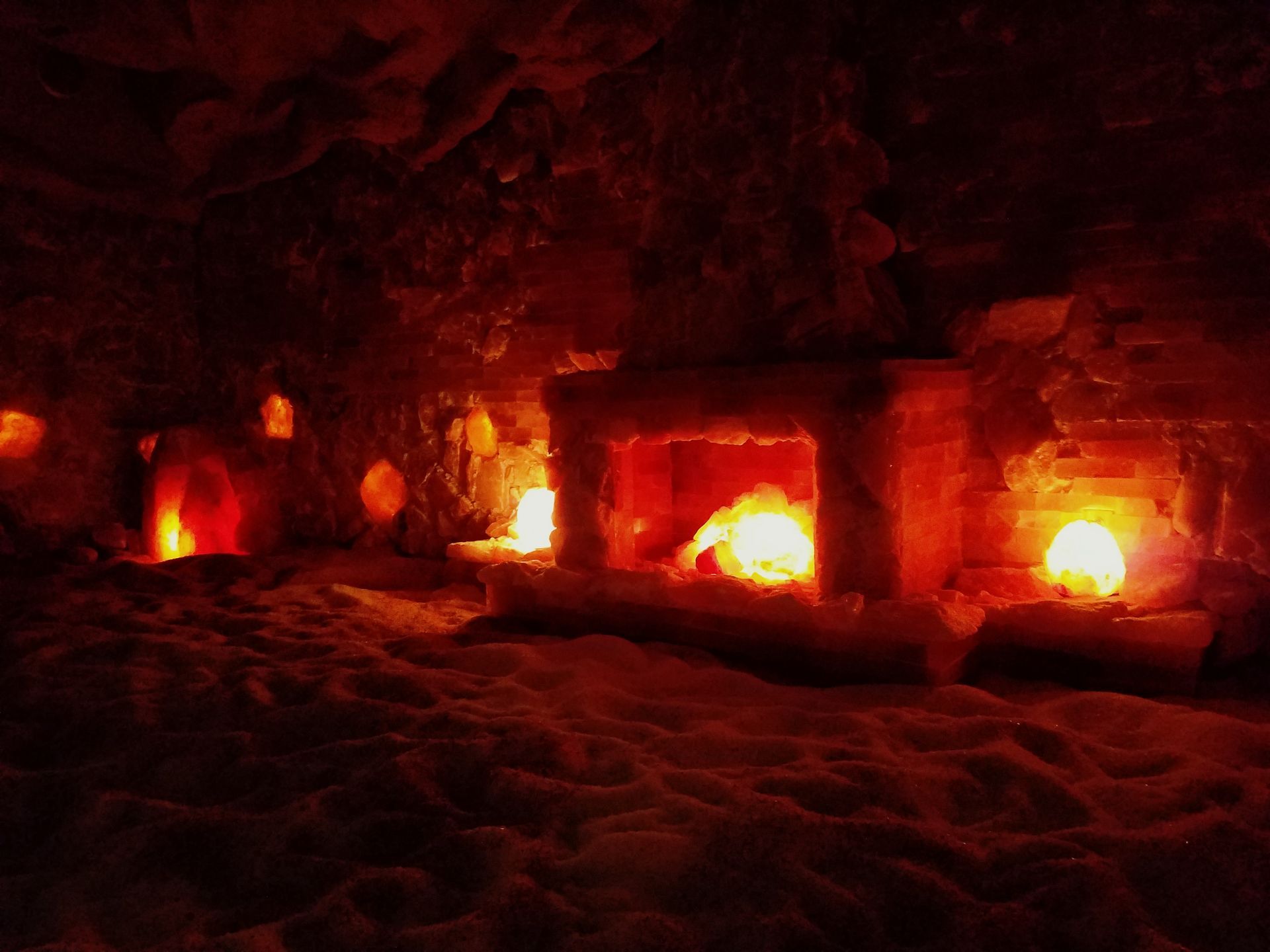 A fireplace in a cave with candles lit up.