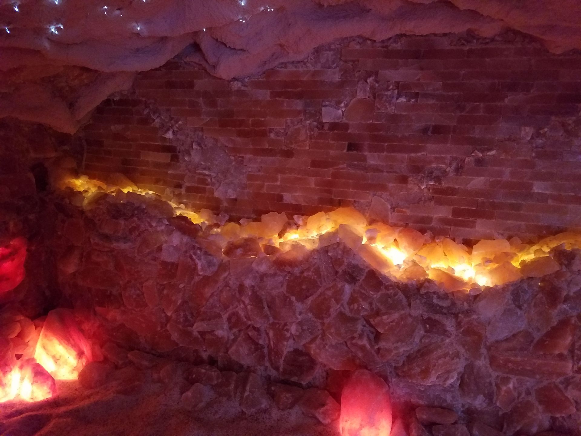 A cave with a lot of rocks and lights on the wall