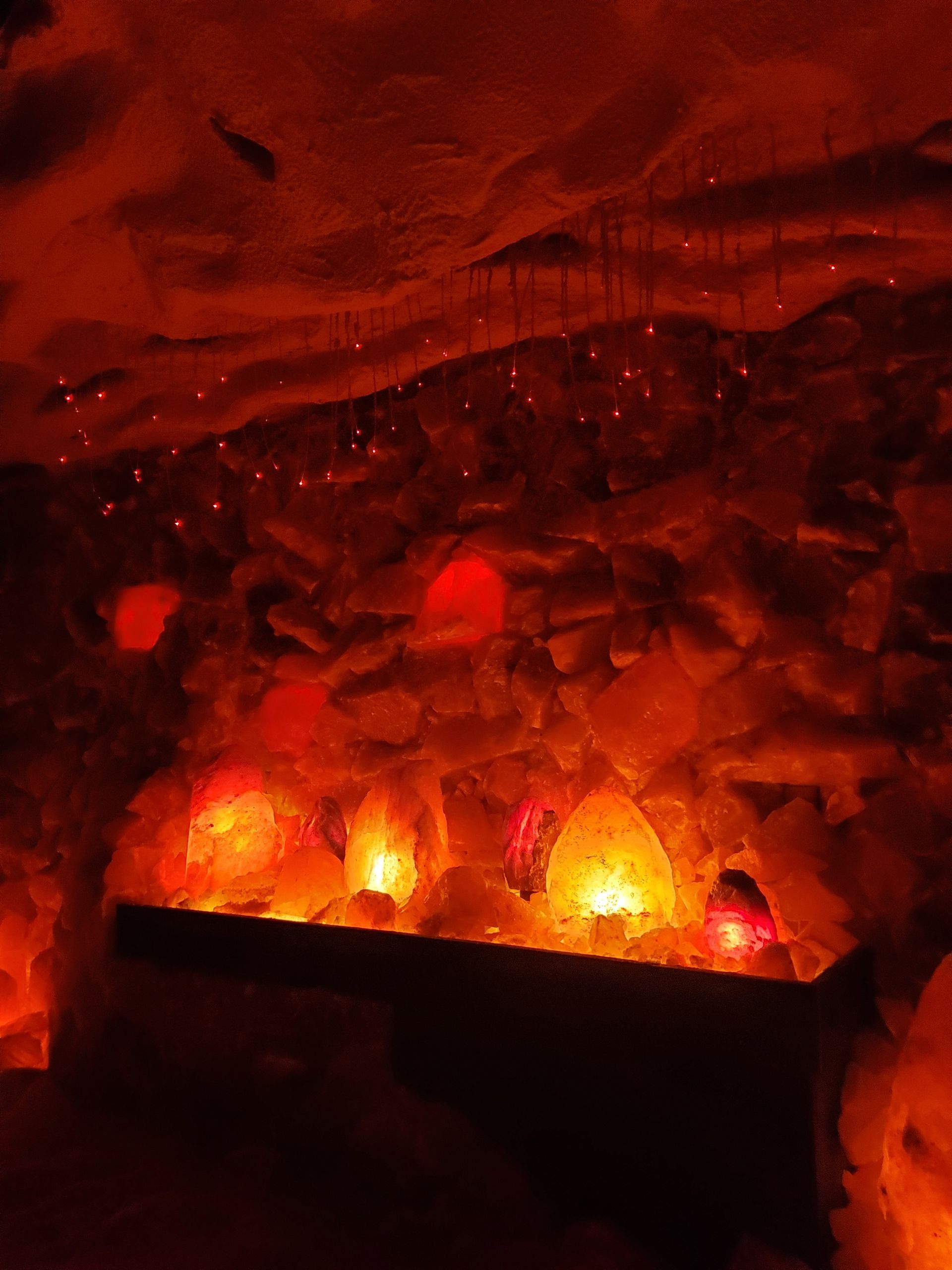 A cave filled with rocks and candles lit up at night.