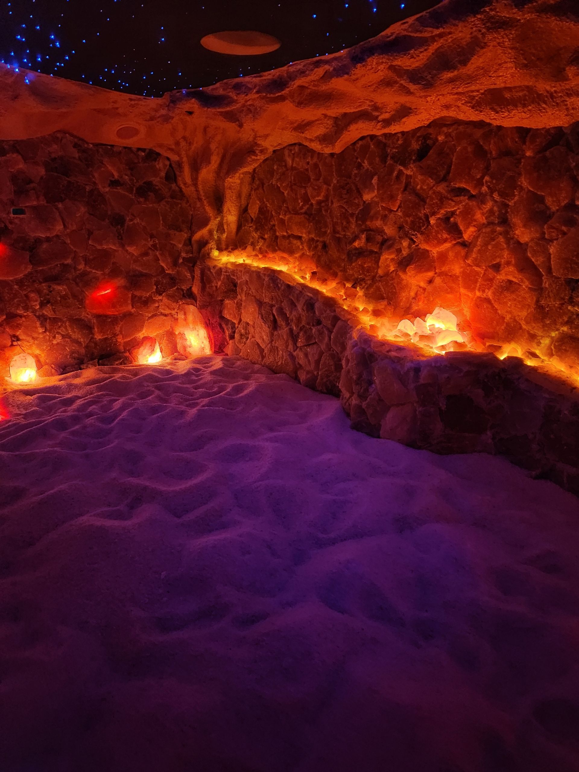 A salt cave with candles and lights on the walls and ceiling.