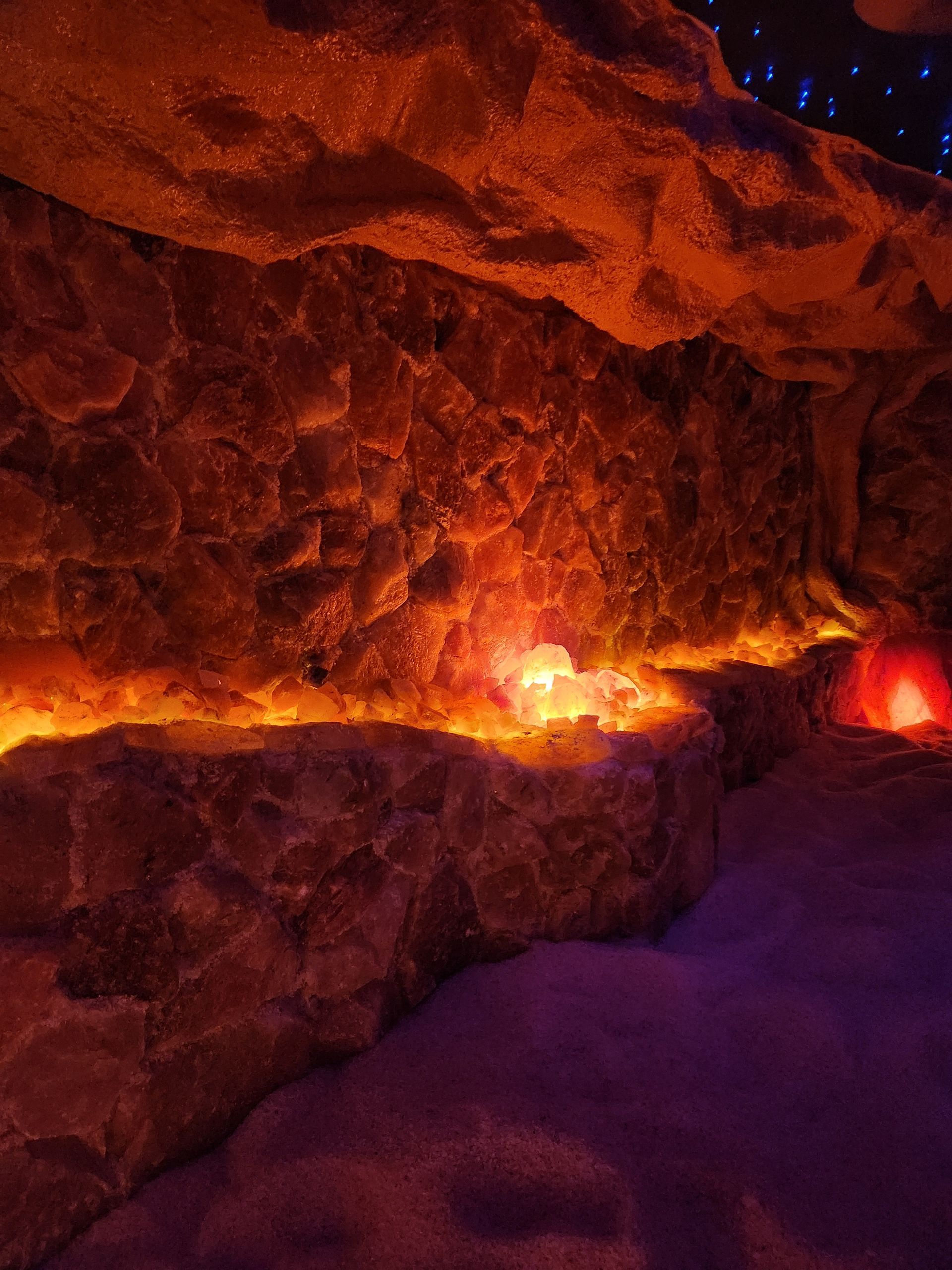 A cave with a lot of rocks and lights on the walls.