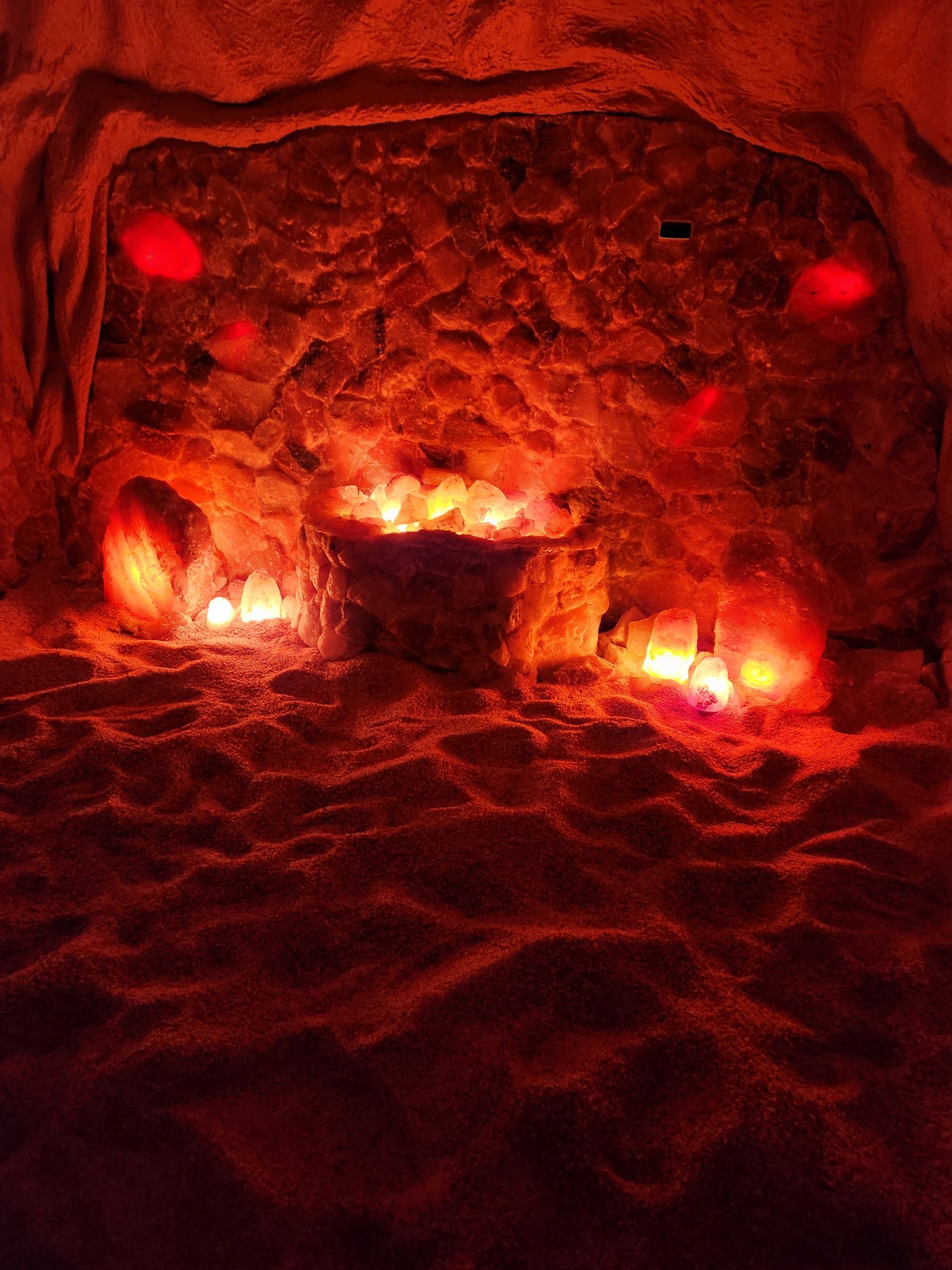 A cave filled with rocks and candles in the dark.