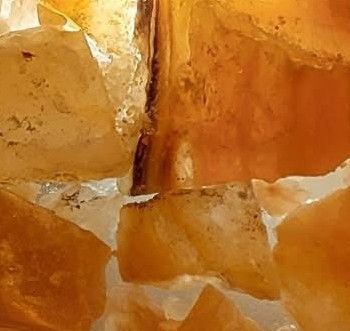 Golden calcite crystals, close-up, with translucent, warm amber and white hues.