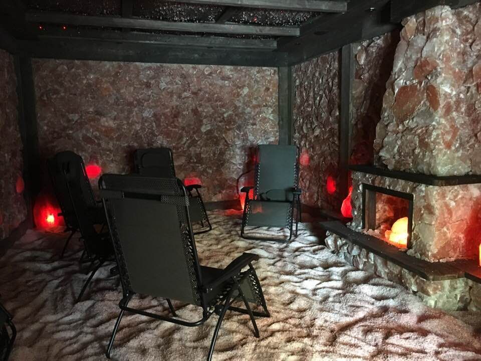 Salt cave with chairs and a fireplace in it.
