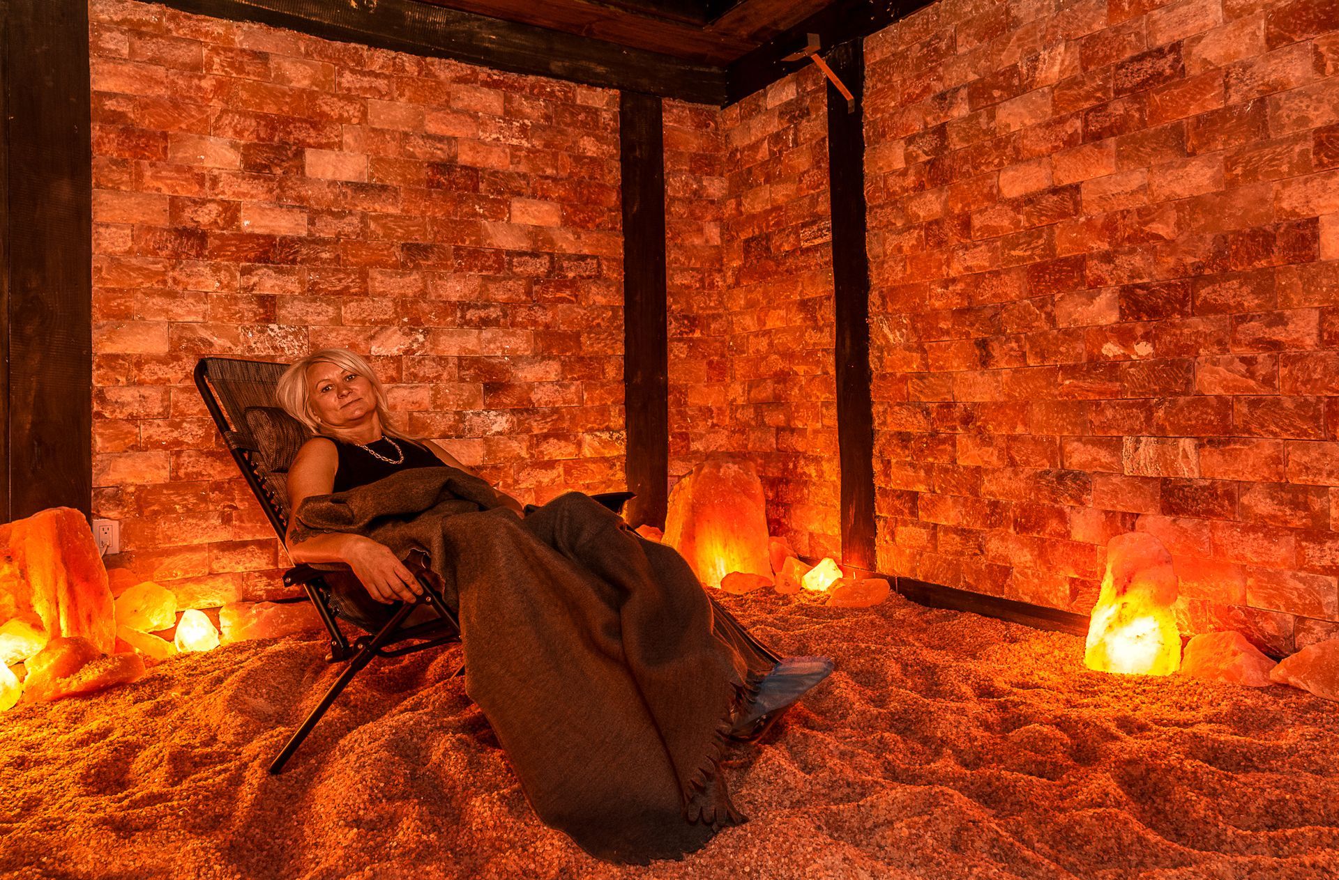 A woman is laying in a chair in a salt room.