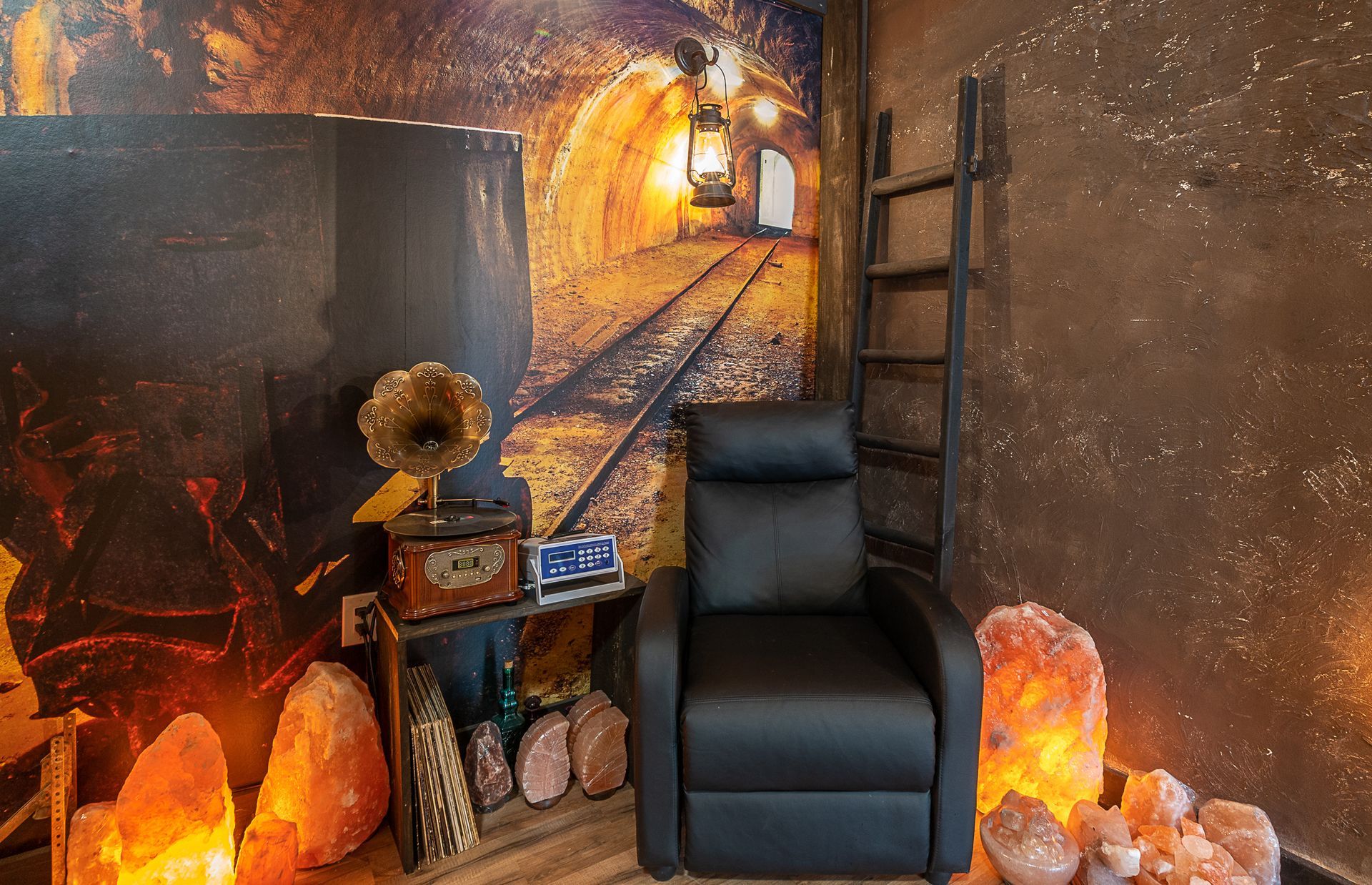 A chair is sitting in Salt cave with a picture of a train on the wall.