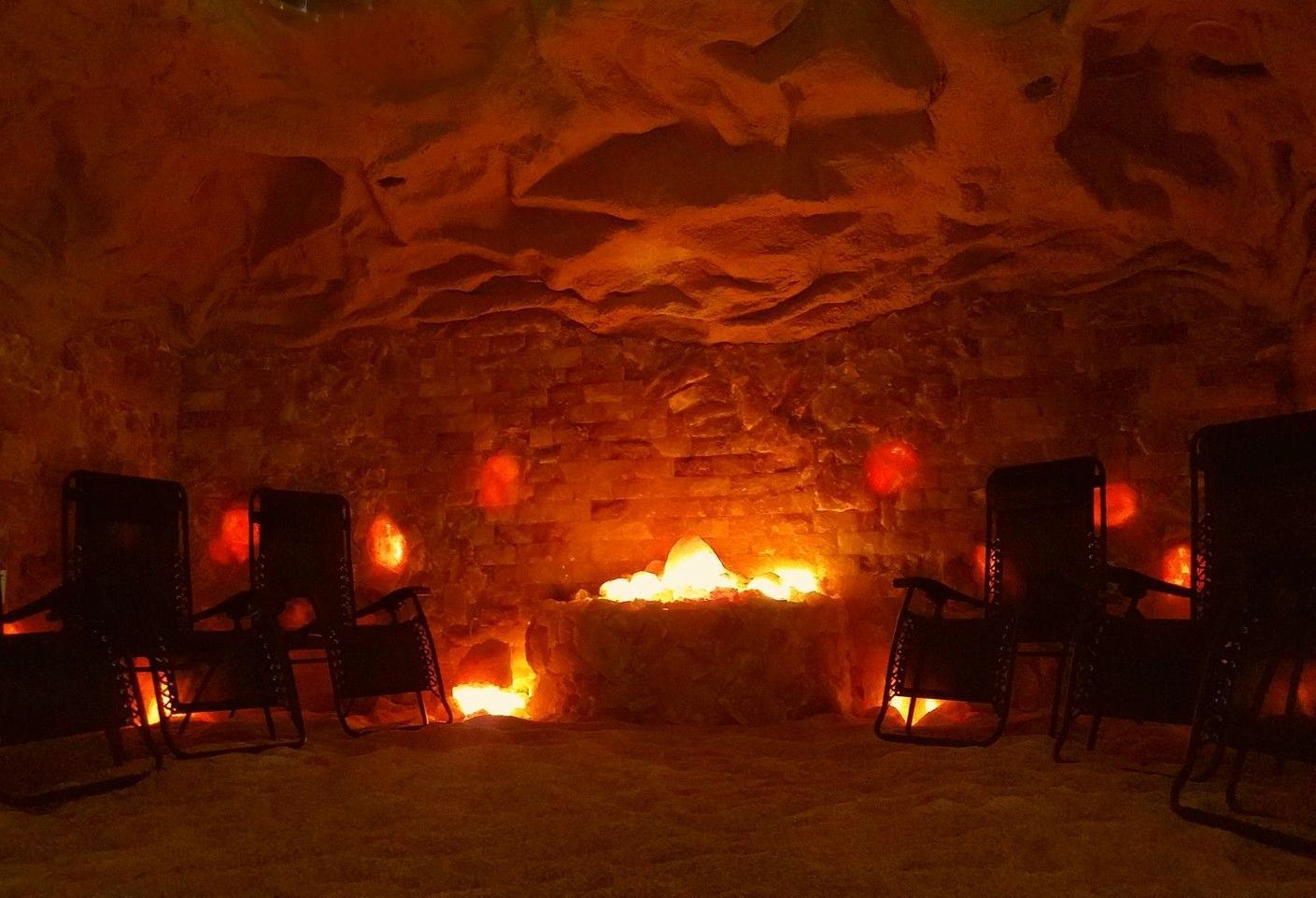 Salt cave with rocking chairs and a fireplace in it.