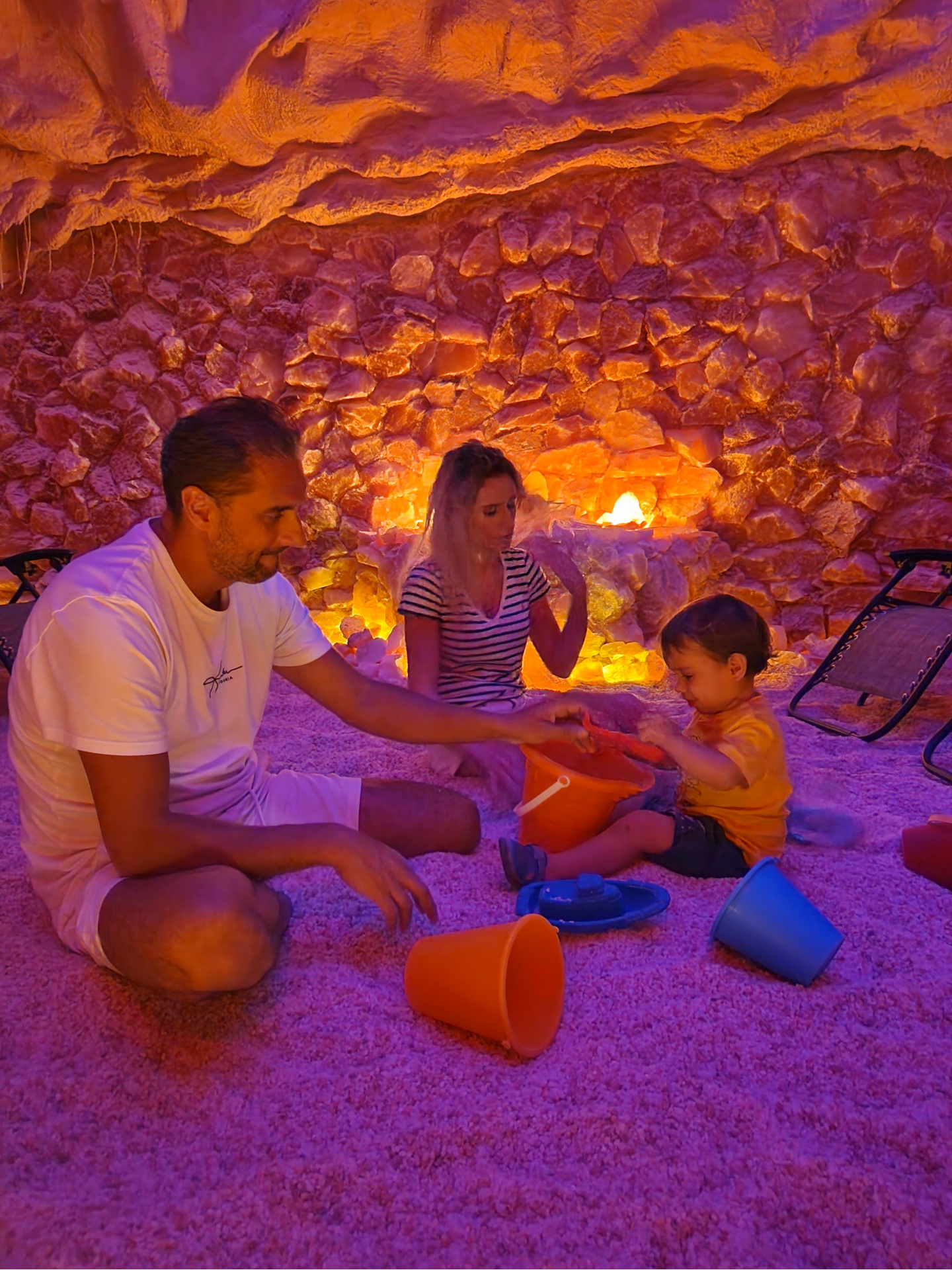 A man , woman and child are playing in a salt cave.