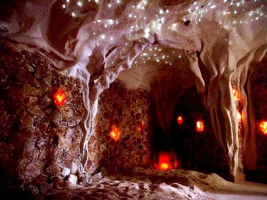 A cave filled with rocks , candles , and lights.