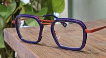 Un jeune garçon portant des lunettes et une chemise noire
