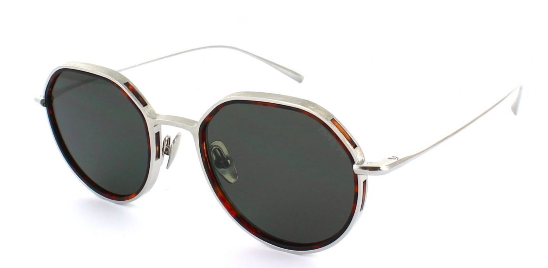 Une paire de lunettes de soleil rondes avec une monture argentée et des verres noirs sur fond blanc.