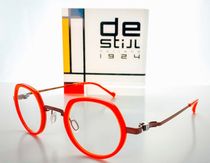Une paire de lunettes posée sur une table à côté d'un panneau indiquant de stijl 1924