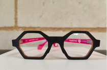 Une paire de lunettes de forme hexagonale avec des montures roses