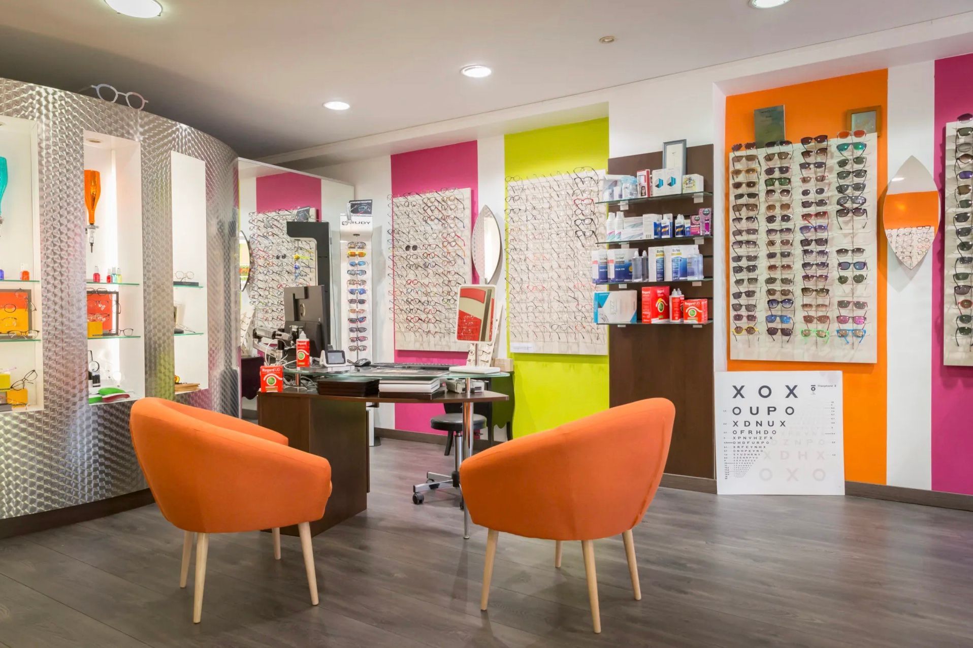 Une pièce avec deux chaises orange et un bureau.