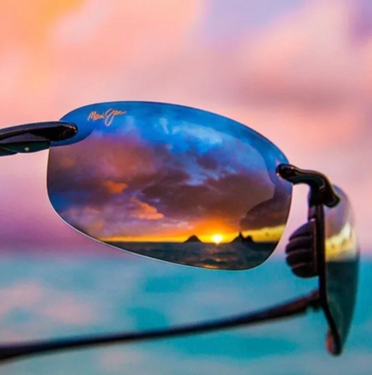 Une paire de lunettes de soleil avec un reflet d'un coucher de soleil dans les verres.