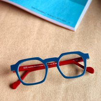 Une paire de lunettes bleues et rouges est posée sur une table à côté d'un livre