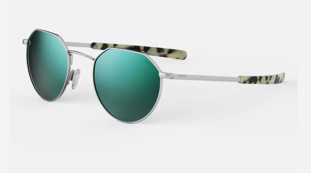Une paire de lunettes de soleil rondes avec des verres verts sur fond blanc.