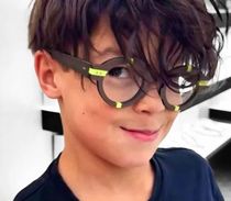 Un jeune garçon portant des lunettes et une chemise noire