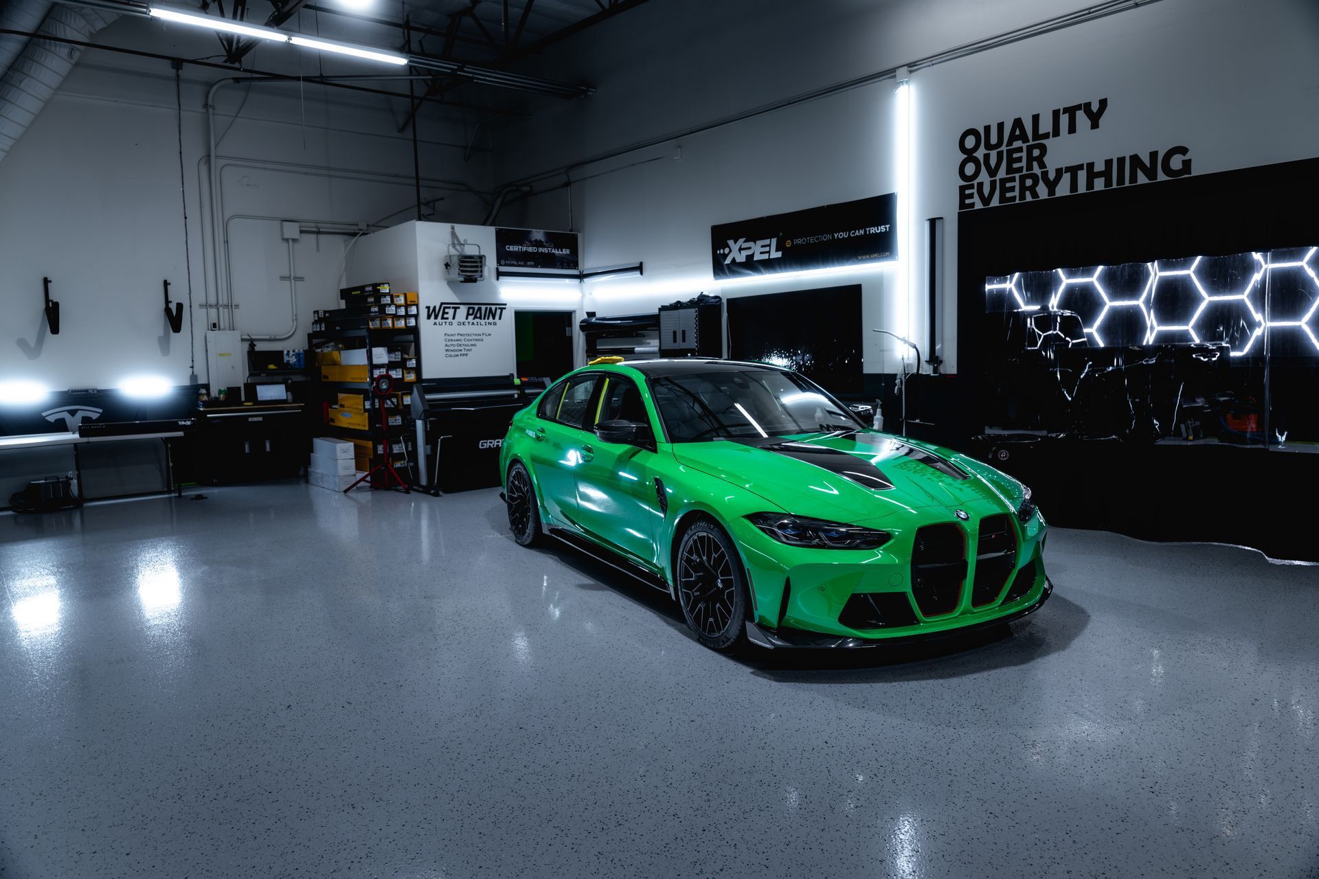 Green BMW sports car in a garage with black accents. 