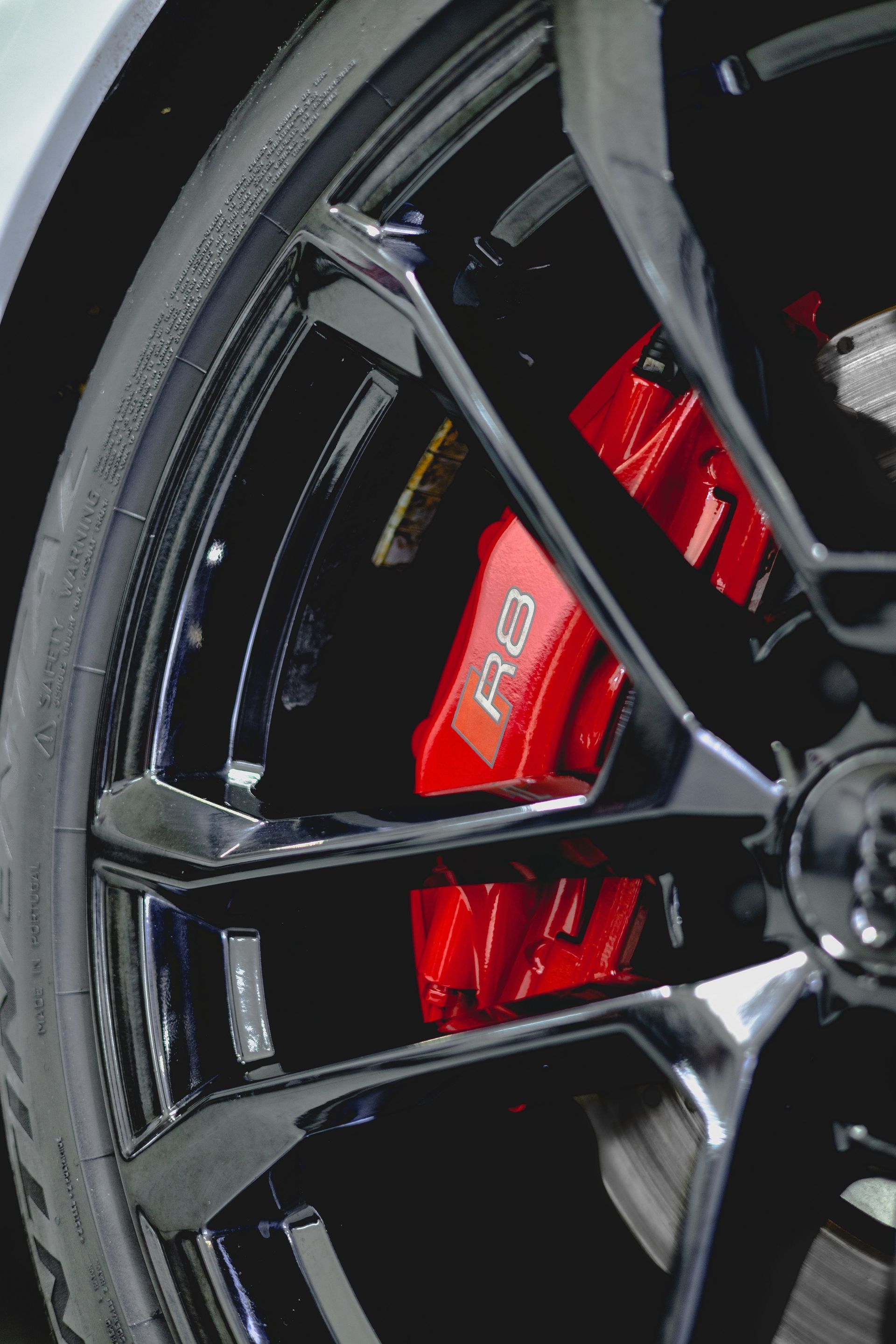 A close up of a car wheel with red brake calipers
