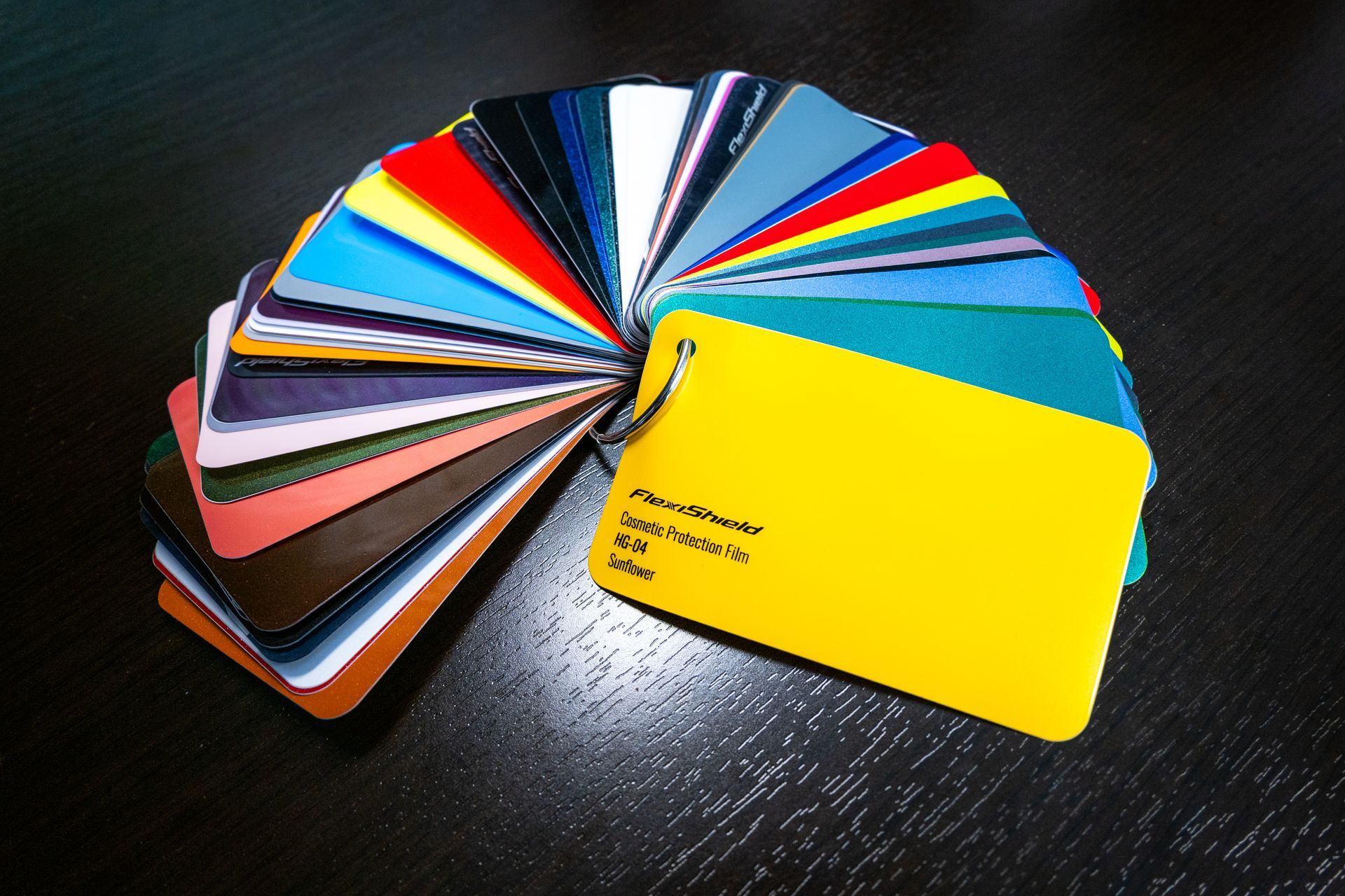 Pink car hood with reflections of overhead lights.