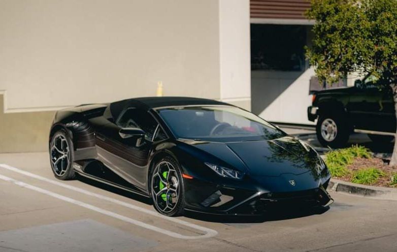 A black lamborghini huracan is parked in a parking lot.