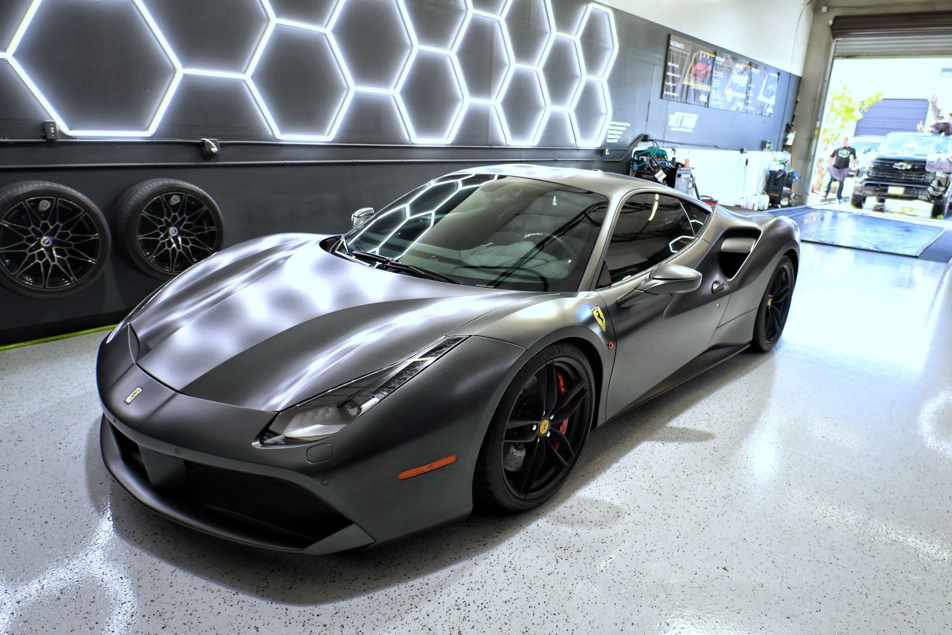 A ferrari 488 gtb is parked in a garage.