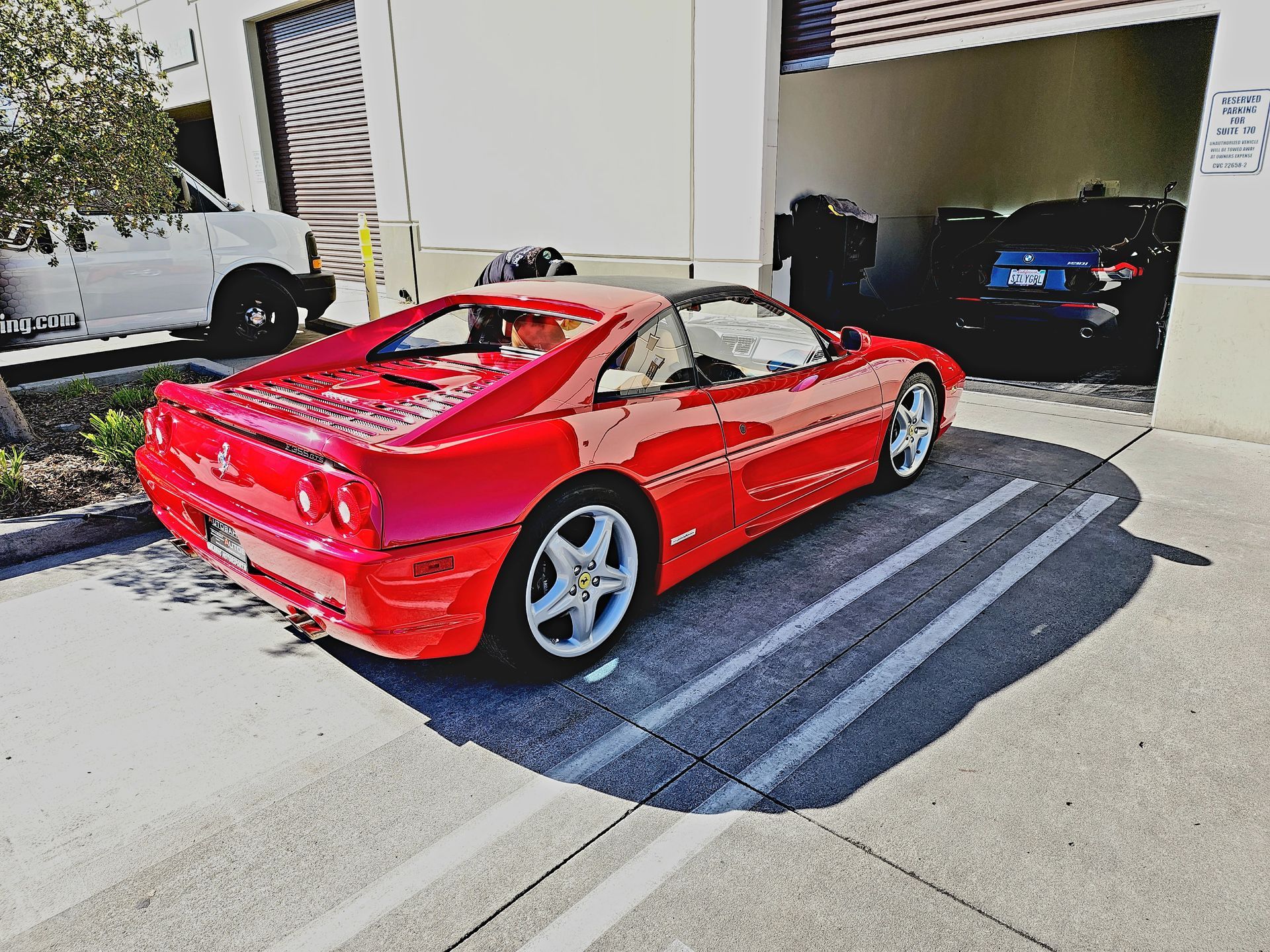 A red sports car is parked in front of a garage