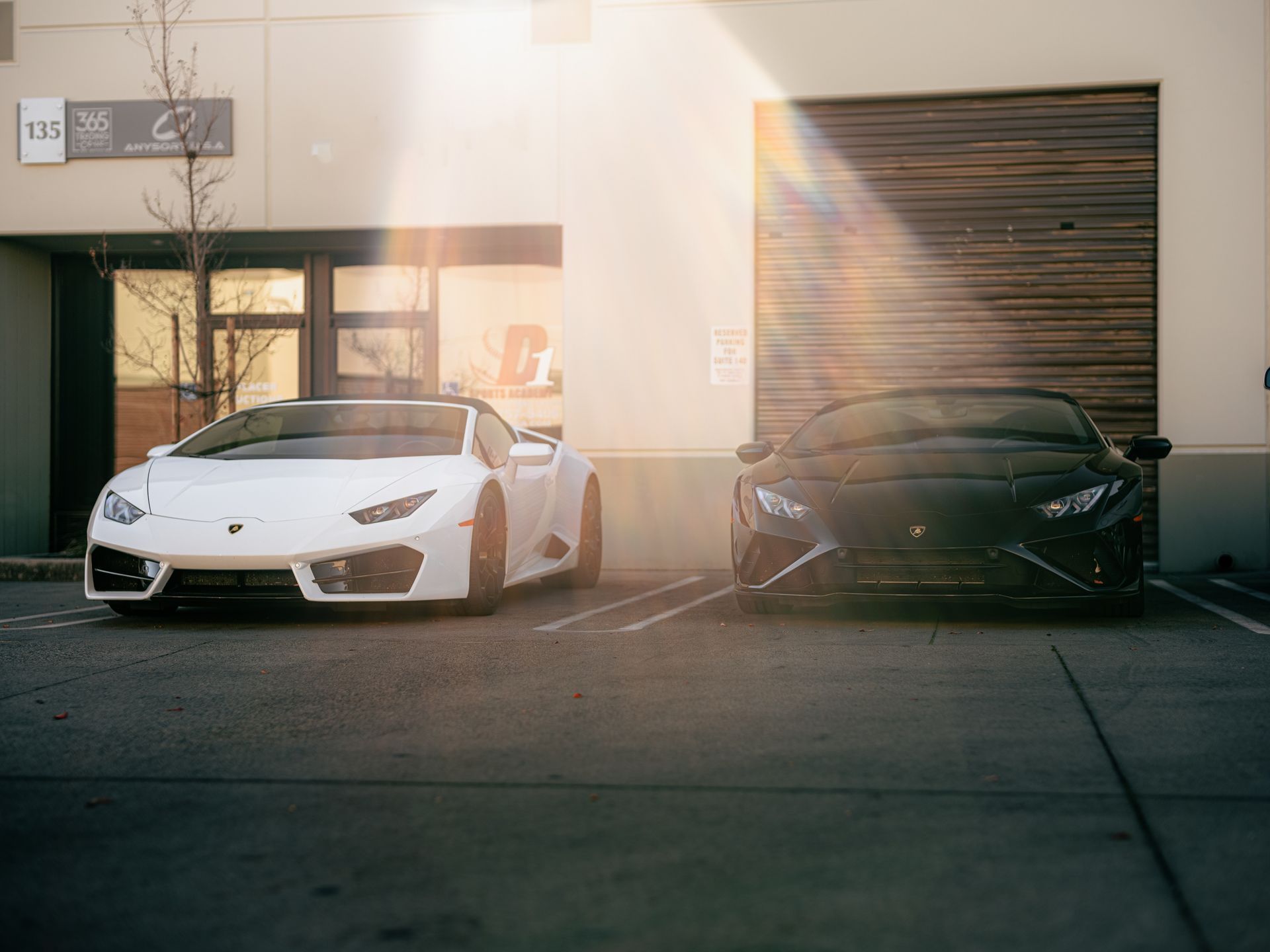 Two sports cars are parked next to each other in a parking lot.
