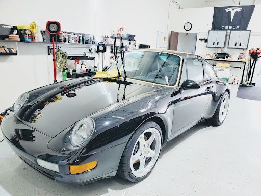 Classic black Porsche coupe with paint protection film in a detailing garage