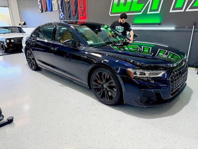 Dark blue Audi A8 receiving ceramic coating treatment inside the Wet Paint detailing garage