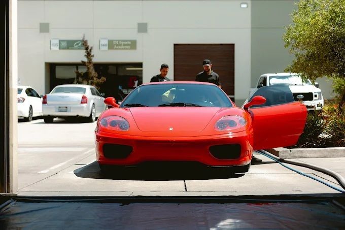 Red Ferrari 360 parked outside Wet Paint shop, arriving for a professional ceramic coating service